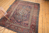 Antique Kurdish Bijar rug corner showing perimeter tatter and worn geometric floral patterns.
