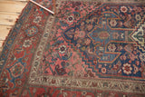 Worn blush, sky blue, and ivory geometric flower motifs on antique Kurdish Bijar rug.
