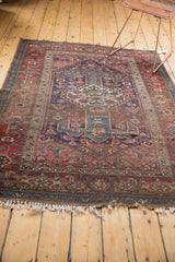 Frayed white fringe with perimeter tatter on a red and blue antique Bijar rug.