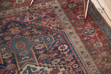 Antique Kurdish Bijar rug detail: navy geometric patterns, blush floral motifs, and wine red border.