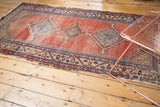 Antique Malayer runner detail: geometric blue medallion, abrash-striated cinnabar field, traditional borders, mostly even wear.