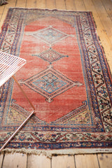 Tattered fringe and intricate navy blue geometric border on the antique Malayer runner.