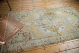 Distressed octagonal medallion displaying faded beige and green tones with foundation etching.