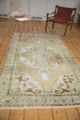 Faded octagonal medallion and scalloped contours on a vintage distressed Oushak rug.