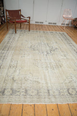 Secured fringe and even wear on the distressed beige vintage Oushak carpet.