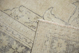 Light beige distressed Oushak rug showing worn pile texture and tight hand-knotted reverse.