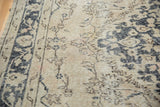 Distressed Sivas carpet detail, charcoal floral vinery on antique ivory field with blush hints.