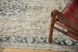 Distressed Sivas carpet: ornate rococo vinery on beige, showing visible foundation wear.
