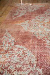 Distressed vintage Oushak rug showing worn cherry red field and subtle ivory rococo patterns.
