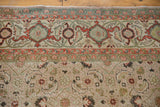 Distressed vintage Kaisary carpet detail: apricot herati motif and green samovar border.