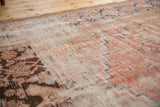 Distressed low pile surface of an antique Hamadan, with primitive rectilinear patterns in blush, blue, brown.