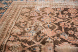Blush, brown, and sky blue Herati pattern detail on a distressed antique Hamadan rug runner.