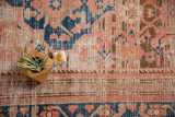 Detail of antique distressed Hamadan rug with low pile, blush, sky blue, and rectilinear motifs.
