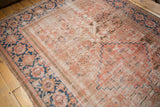 Distressed antique Hamadan runner reveals faded blush, ivory, and blue rectilinear motifs.