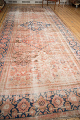 Distressed antique Hamadan runner end with faded primitive motifs, low pile, and visible fringe.