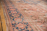 Distressed blush and blue antique Hamadan runner's low pile and primitive rectilinear border.