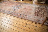 Distressed antique Hamadan runner section with low pile and prominent chocolate brown patch.