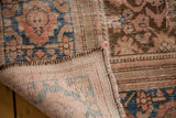Distressed antique Hamadan rug, revealing low pile, hand-knotted foundation, and faded tones.