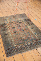 Distressed vintage Belouch rug displaying geometric guls, a prayer mehrab, and even pile wear.