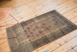 Distressed vintage Belouch rug showcasing faded geometric guls in copper, blush, and sky blue.