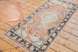 Faded brick red, ivory palmettes, and charcoal border on a distressed Oushak runner.