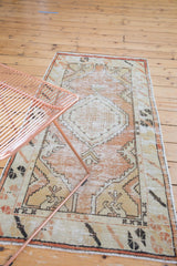 Distressed Oushak runner showcasing faded dusty rose and sand diamond medallion and floral motifs.