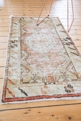 Oushak runner end close-up, highlighting distressed pile, fringe, and beige floral motifs.