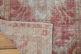 Folded corner of a vintage Oushak rug revealing its hand-knotted foundation and weave.