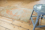 Distressed vintage Oushak rug with mostly even wear, tangerine orange, and neutral tones.