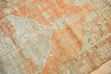 Distressed texture and pale tangerine orange with ivory knot heads on vintage Oushak.