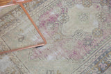 Faded mauve and ivory distressed Oushak rug texture showing areas of foundation.
