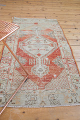 Distressed vintage Oushak runner showing faded brick red geometric motifs and even wear.