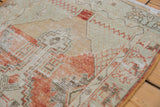 Worn texture of vintage distressed Oushak runner with faded brick red and seafoam green geometrics.