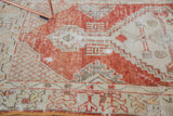Distressed pile with faded red and ivory geometric stepped patterns on vintage Oushak runner.