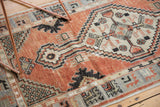 Distressed Oushak runner corner with faded cherry red, ivory, and slate blue primitive floral motifs.