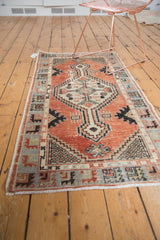 Distressed Oushak runner corner: faded cherry red, primitive slate blue border, lattice spandrel.