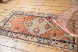 Distressed Oushak rug runner: faded brick red central medallion with serrated sickle leaves.