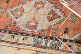 Distressed Oushak runner showing even wear, intact selvage, and brick red geometric motifs.