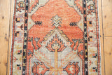 Distressed vintage Oushak rug: softened pile, geometric patterns, intact side cord.