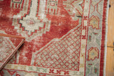 Distressed cherry red and ivory textured pile with geometric lattice and floral border of vintage Oushak.