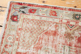 Distressed Oushak runner with worn cherry red pile and primitive floral border.