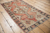 Distressed Oushak runner, faded cherry red, charcoal medallion, and floral border.