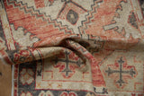 Distressed Oushak rug's faded red, charcoal, and ivory abrashed texture.