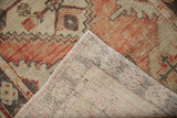 Hand-knotted foundation and fringed edge of the distressed Oushak runner, showing wear.