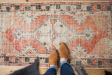 Distressed Oushak rug's faded cherry red and antique ivory diamond medallion.