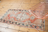 Distressed Oushak rug's diamond medallion with faded cherry red and ivory abrash.
