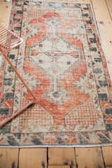Distressed Oushak runner lower corner, faded red, ivory abrash, primitive border, fringe.