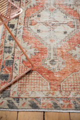 Distressed Oushak runner's primitive floral border in faded cherry red and ivory.