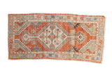 Distressed Oushak runner with faded cherry red, geometric medallion, and palmette accents.