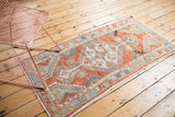 Primitive floral border of distressed Oushak runner in faded cherry red, seafoam green, slate blue.